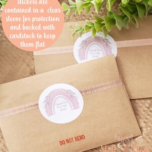 May include: A brown paper envelope with a "Thank You For Your Order" sticker featuring a rainbow with floral accents. The envelope has a red "DO NOT BEND" label and is sealed with a pink ribbon.