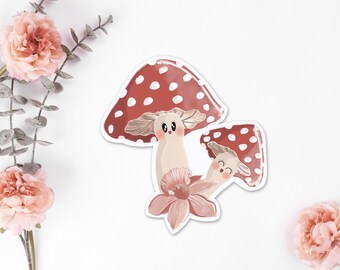 May include: Two cartoon mushrooms with red and white dotted caps and smiling faces. The larger mushroom has a pink flower at its base.