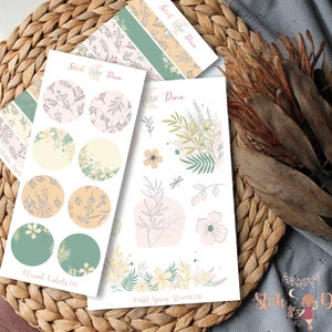 May include: A set of floral themed stickers with a pastel color scheme. The stickers include a sheet of round labels with floral patterns, a sheet of pastel spring flowers, and a sheet of floral patterned washi tape.