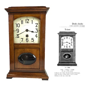 May include: A wooden desk clock with a black face and white numbers. The clock has a pendulum and a small black knob on the bottom. The clock is labeled "Triest" and "No. 1335".