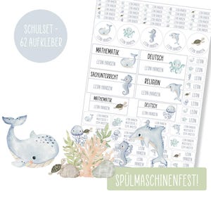 Könnte beinhalten: Ein Set mit 62 blauen und weißen Schulaufklebern mit Wal, Tintenfisch, Seepferdchen, Schildkröte und Qualle. Die Aufkleber sind für Schulsachen gedacht und beinhalten den Text "SCHULSET - 62 AUFKLEBER" und "SPÜLMASCHINENFEST!"