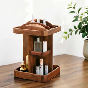 Könnte beinhalten: Ein drehbarer Holz-Organizer mit mehreren Ebenen und Fächern zur Aufbewahrung verschiedener Hautpflege- und Kosmetikflaschen. Die dunkelbraune Holzstruktur verfügt über eine quadratische Basis und Oberseite mit vertikalen Trennwänden.