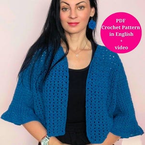 Può includere: Un cardigan in crochet blu con un motivo traforato. Il cardigan ha un collo a V e maniche 3/4. Il modello include uno schema di uncinetto PDF in inglese e un tutorial video.