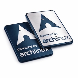 May include: Two rectangular metal badges with rounded corners, featuring the Arch Linux logo and the text "powered by archlinux". One badge has a dark blue brushed finish with silver text, while the other has a silver brushed finish with dark blue text.