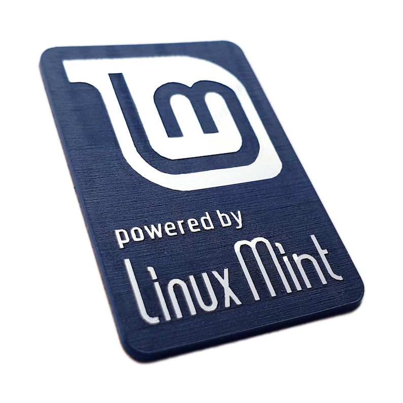 May include: A dark blue sticker with a white Linux Mint logo and the text "powered by Linux Mint".