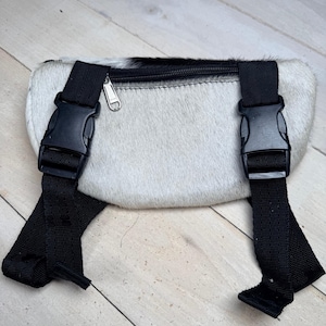 May include: A set of three ceramic mugs with a speckled, matte finish. The mugs are in shades of cream, light gray, and dark gray. Each mug has a simple, minimalist design and a rounded handle.