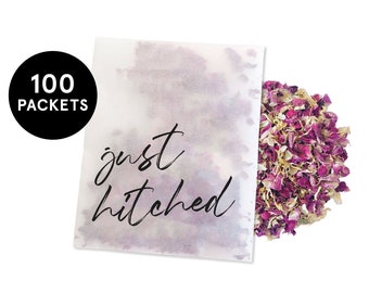 May include: A white paper bag with the text "just hitched" printed in black. The bag is filled with dried rose petals and is labeled with "100 packets".