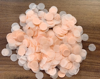 May include: A pile of peach-colored and white paper confetti circles. The confetti is made of tissue paper and is perfect for adding a festive touch to any celebration.