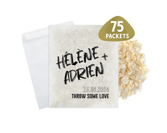 May include: A white paper bag with the text "HÉLÈNE + ADRIEN 15.06.2024 THROW SOME LOVE" printed on it. The bag is filled with white confetti and has a gold sticker with the text "75 PACKETS" on it.
