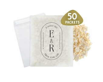 May include: A set of 50 white paper packets with a personalized design. The packets feature the initials "E & R" and the date "31 August 2025". The text "Throw some love" is also included on the packets.