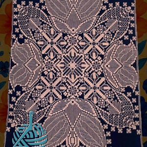 Pode incluir: Um cobertor de crochê em mosaico azul marinho e rosa claro com um padrão geométrico. O cobertor apresenta um design central em forma de estrela com elementos semelhantes a folhas e bordas decorativas. O texto "A do Crochet Mosaic by Betsy Sickler" está na parte inferior.