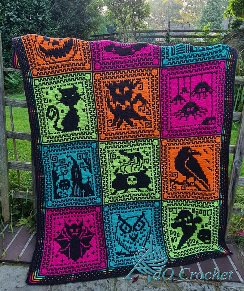 May include: A black crochet blanket with a colorful patchwork design featuring various Halloween-themed motifs, including a jack-o-lantern, a cat, a ghost, a spider, a cauldron, a raven, a bat, an owl, and a skeleton. The blanket is made with bright neon colors, including orange, green, pink, and blue.