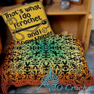 May include: A colorful crochet blanket with a geometric pattern in shades of yellow, orange, green, and black. A smaller yellow pillow with the text "That's what I do I crochet and I know things" is on top of the blanket.
