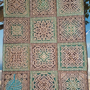 May include: A mosaic crochet blanket featuring a repeating geometric design in cream, black, and teal. The blanket is composed of square panels with detailed patterns. The text "ado Crochet" and "Mosaic by Christina O'Connor" is visible.