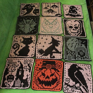 May include: A set of 12 crocheted Halloween-themed squares featuring various designs, including a cat, an owl, a skull, a witch, a pumpkin, a raven, and a ghost. The squares are made with black and white yarn and have a variety of colors, including orange, green, and pink.