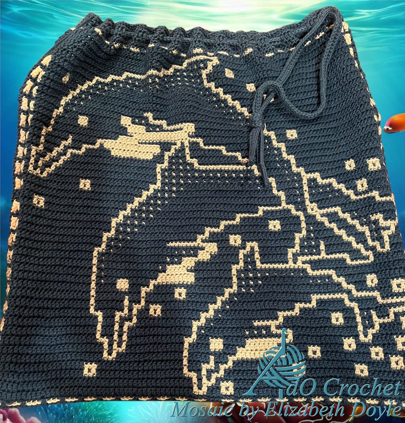 Peut inclure: Un sac en crochet bleu fonc&eacute; avec un motif de dauphin beige. Le sac a une fermeture &agrave; cordon et le texte "Mosiac by Elizabeth Doyle" est visible en bas.