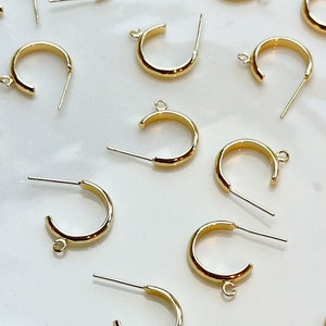 Puede incluir: Un plato blanco con una colección de hallazgos de pendientes de aro dorados. Los hallazgos tienen un pequeño bucle en la parte superior y un poste recto en la parte inferior.