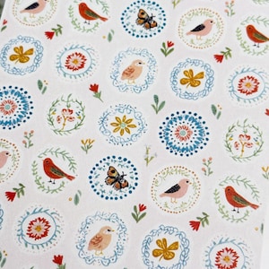 May include: A white rectangular surface featuring a repeating pattern of circular motifs. Each circle contains illustrations of small birds, butterflies, or flowers in shades of red, blue, yellow, and green, interspersed with small floral sprigs.