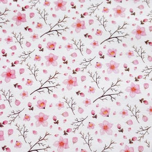 Peut inclure: Un motif sans couture représentant de délicates fleurs roses en aquarelle et des branches sur un fond blanc. Les fleurs sont dispersées dans tout le motif, avec quelques pétales tombant des branches. Le motif est parfait pour ajouter une touche de printemps à tout projet.