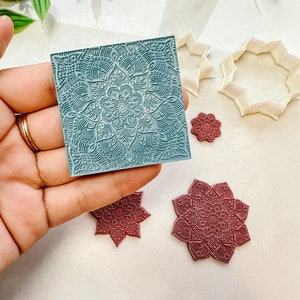 May include: A set of four blue and burgundy silicone stamps featuring intricate mandala designs. The stamps are ideal for creating unique patterns on crafts and baked goods.