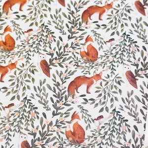 May include: A repeating pattern featuring foxes, owls, and floral elements. The foxes are depicted in shades of orange and brown, while the owls are brown and white. Green leaves and pink flowers are interspersed on a white background.