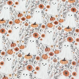 Può includere: Un tessuto bianco con un motivo ripetuto di fantasmi amichevoli, zucche arancioni e fiori autunnali. Il design presenta uno stile stravagante e disegnato a mano, perfetto per l'artigianato e le decorazioni a tema Halloween.