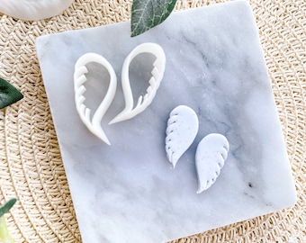 Peut inclure: Deux paires de boucles d'oreilles en forme d'ailes d'ange blanches, une paire est un moule et l'autre paire est en pâte polymère.