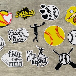 Op de afbeelding: Een set van 12 softball-thema stickers met verschillende ontwerpen, waaronder een softball met een hart, een rennende speler en de tekst "Eat Sleep Home Run Repeat".