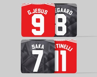 May include: Four soccer jerseys with different player names and numbers. The jerseys are red and black with white numbers. The names on the jerseys are G. Jesus 9,  Egaard 8, Saka 7, and Martinelli 11.