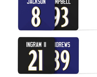 Peut inclure: Deux ensembles de patchs de maillot noir et bleu avec des chiffres blancs et des contours dorés. L'ensemble du haut indique "JACKSON 8" et "MPBELL 93". L'ensemble du bas indique "INGRAM II 21" et "IDREWS 39".