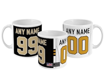 May include: Two white ceramic mugs with black and white designs. One mug has a black background with a gold number 99 and the text "ANY NAME". The other mug has a white background with a gold number 00 and the text "ANY NAME".