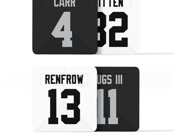 Puede incluir: Cuatro parches de camiseta negros y blancos con los nombres "Carr", "Renfrow", "Witten" y "Jugs III" y sus números correspondientes 4, 13, 82 y 11.