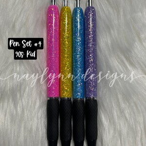 May include: Set of four glitter pens with black ink. The pens have a black rubber grip and a silver top. The glitter colors are pink, yellow, blue, and purple. The text "Pen Set #4 90s Kid" is visible in the image.