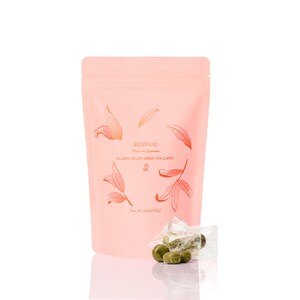 May include: A pink pouch with the text "BENIFUKI Premium Japanese ALLERGY RELIEF GREEN TEA CANDY" and a drawing of green tea leaves. The pouch contains green tea candies in clear plastic wrappers.