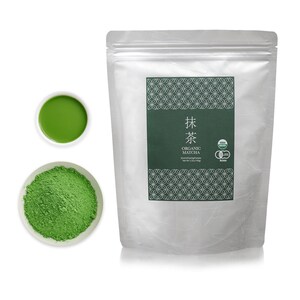 May include: A silver pouch with a green label that says "抹茶 ORGANIC MATCHA" and has a green and white pattern. The pouch contains green matcha powder. There is a small white bowl with green matcha powder and a small white bowl with green matcha tea.