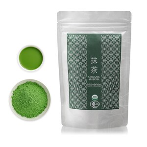 May include: A silver pouch with a green label that says "抹茶 ORGANIC MATCHA" and has a green pattern. The label also includes the text "15x0.07oz(2g) Packets Net Wt 1.05oz(30g)" and has USDA Organic and JAS logos. The pouch is sitting on a white surface. There is a small white bowl with green matcha powder and a small white bowl with green matcha tea.