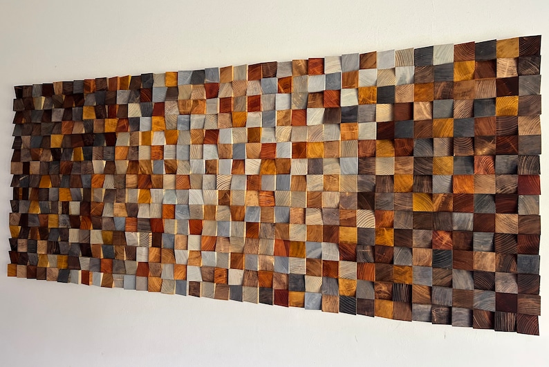 K&ouml;nnte beinhalten: Ein Wandkunstwerk aus Holz mit einer Vielzahl von Farben und Texturen. Das Holz ist in Wellenform angeordnet und erzeugt so einen einzigartigen und modernen Look.