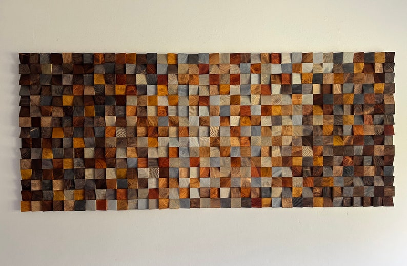 K&ouml;nnte beinhalten: Ein Wandkunstwerk aus Holz mit einem Mosaikmuster. Das Holz ist in verschiedenen Farben, darunter Braun, Grau und Rot. Das St&uuml;ck besteht aus kleinen Holzquadraten, die in einem geometrischen Muster angeordnet sind.