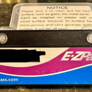 May include: An E-ZPass transponder with a black top and a white, pink, and blue front. The front has the text "E-ZPass" and "I-PASS", with the website getipass.com. A notice is included.