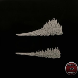 May include: Two grey plastic flame shapes, each with a pointed tip and a jagged, textured edge. The flames are arranged in a vertical stack, with the top flame slightly offset to the right.