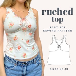 May include: A white tank top with a floral print and a ruched neckline. The top has a tie at the neckline and a ruffle trim. The text "ruched top" and "EASY PDF SEWING PATTERN" is displayed above the top. The text "SIZES XS-XL" is displayed below the top.
