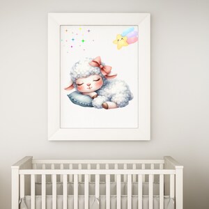 Pu&ograve; includere: Una stampa incorniciata bianca con un'illustrazione ad acquerello di un agnello addormentato con un fiocco rosa. L'agnello &egrave; sdraiato su un cuscino blu con una stella cadente arcobaleno nell'angolo in alto a destra.