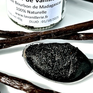 May include: A small glass jar filled with black vanilla caviar, labeled "Caviar de Vanille Vanille Bourbon de Madagascar 100% Naturelle www.lavanillerie.fr DLUO: 01/10/2025".  The jar is sitting on a white surface with vanilla beans.