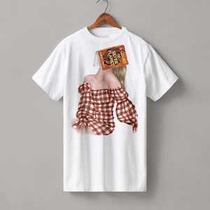 May include: White t-shirt with a watercolor illustration. The design features a person with a red and white checkered off-the-shoulder top and a book covering their face. The book is titled "A Court of Silver Flames".