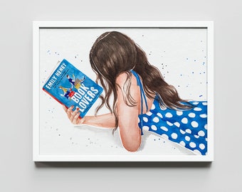 以下が含まれることがあります： 白いフレームに入った水彩画のイラスト。長い茶色の髪で白の水玉模様の青いドレスを着た人物が横になり、エミリー・ヘンリー著の青い本『Book Lovers』を読んでいる様子が描かれており、背景には青い絵の具の飛沫が散らされている。