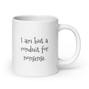 May include: White ceramic coffee mug with black text that reads "I am but a conduit for nonsense."