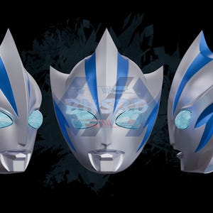 May include: A silver and blue mask with a futuristic design, featuring a prominent crest and angular details. The mask has blue accents and eye openings with a textured appearance. The image shows the mask from multiple angles, with the text "3D FILE" at the bottom.