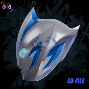 May include: A silver and blue 3D-printed mask with a stylized design. The mask features blue accents and a central, light blue, oval-shaped eye. The text "3D FILE" is visible in the lower right corner.