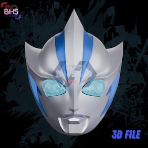 May include: A silver and blue mask with a pointed top and stylized features. The mask has blue accents and eye openings with a textured appearance. The text "3D FILE" is visible in the lower right corner.