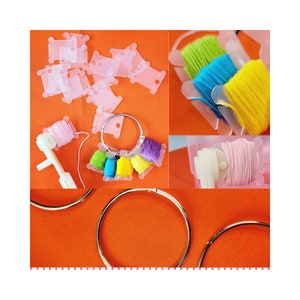 May include: A set of colorful embroidery floss spools organized on a plastic thread organizer. The spools are arranged in a circle on a bright orange surface. The thread organizer is made of clear plastic and has a ring to hold the spools in place. The floss is in various colors, including pink, purple, green, yellow, and blue.